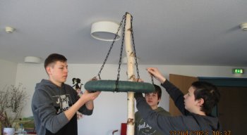 Drei Jungen die kleinen Maibaum dekorieren